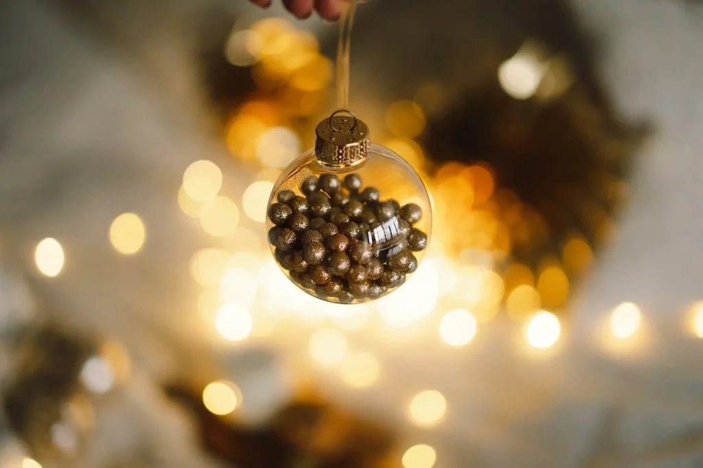 a woman s hand holds a christmas golden ball on a 2023 11 27 05 23 50 utc